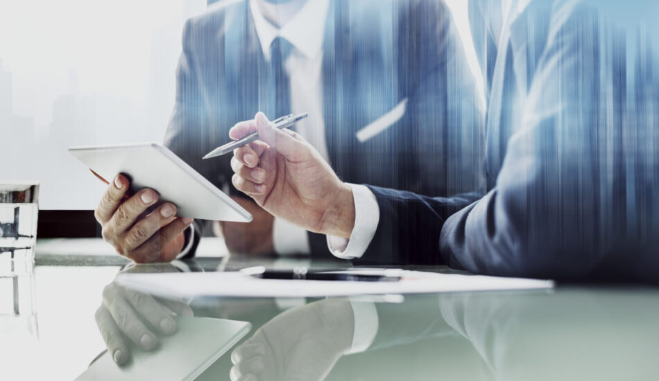 Corporate businessmen working on tablet at office